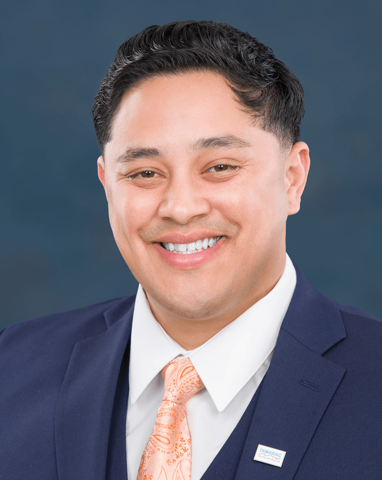 Commissioner Villalobos' Headshot showing blue suit, and peach tie and white shirt. 